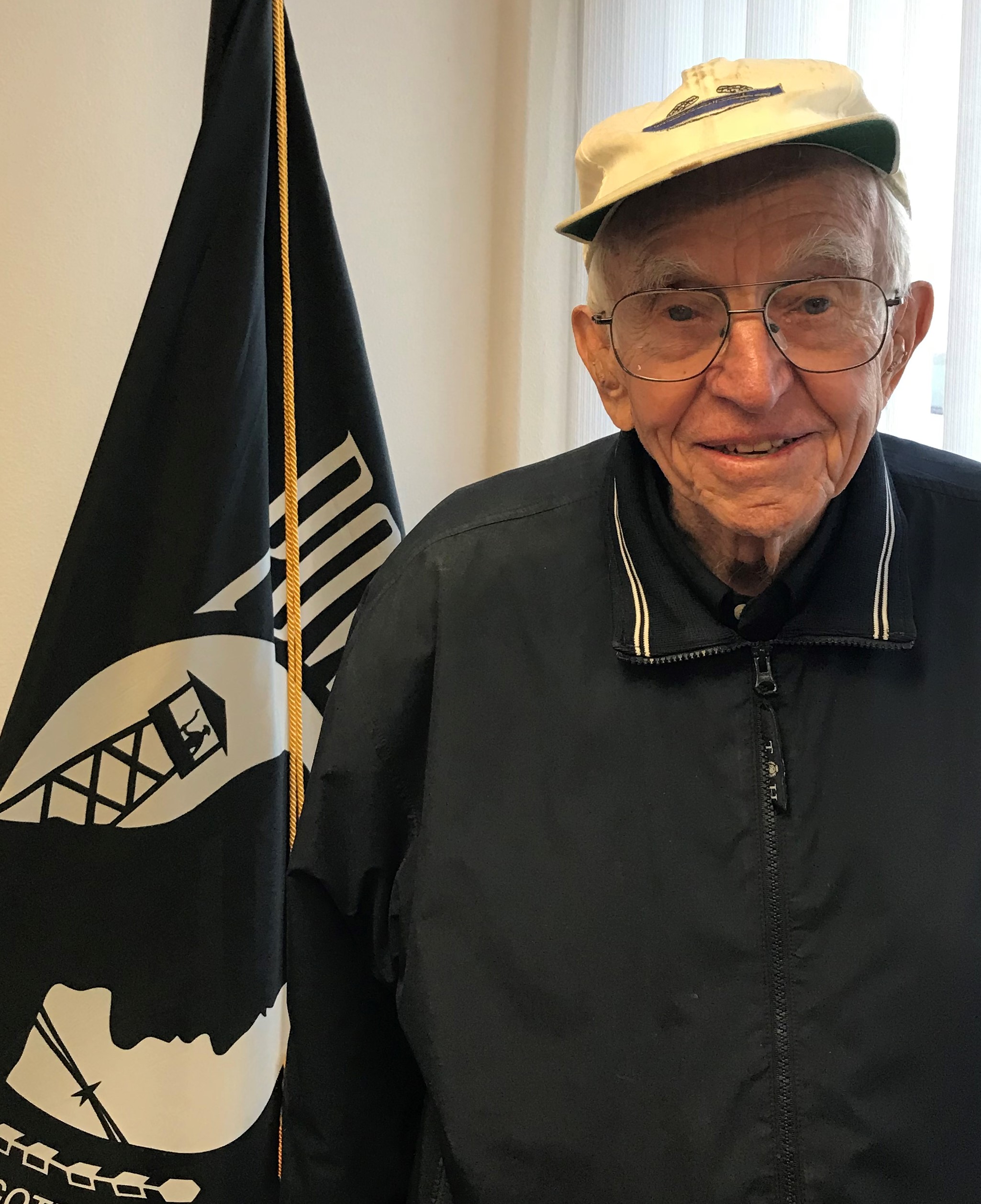 Maurice Bonemeyer in civilian clothes standing in front of flag photo
