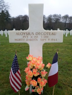Private Aloysius Decoteau grave marker with small flags and flowers photo
