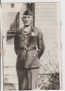 Private First Class Arthur A Clemenson in uniform standing in front of a house photo