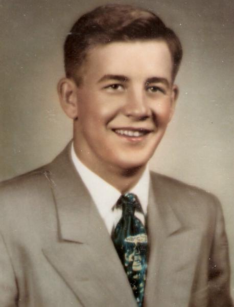 This is a professionally posed mid‑20th‑century portrait of a young man dressed in formal civilian attire.