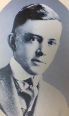 Vintage black-and-white oval portrait of Howard E. Clark in a suit and tie.