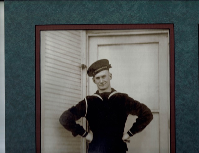 Seaman First Class Earl Nermoe in uniform standing in front of a door photo