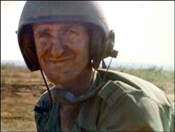 Arlan Gable photo shows in a field environment wearing military headgear.