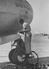 Technical Sergeant Harold E Halldorson in uniform standing facing airplane photo