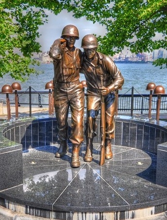 WWII memorial statue with two soldiers' photo