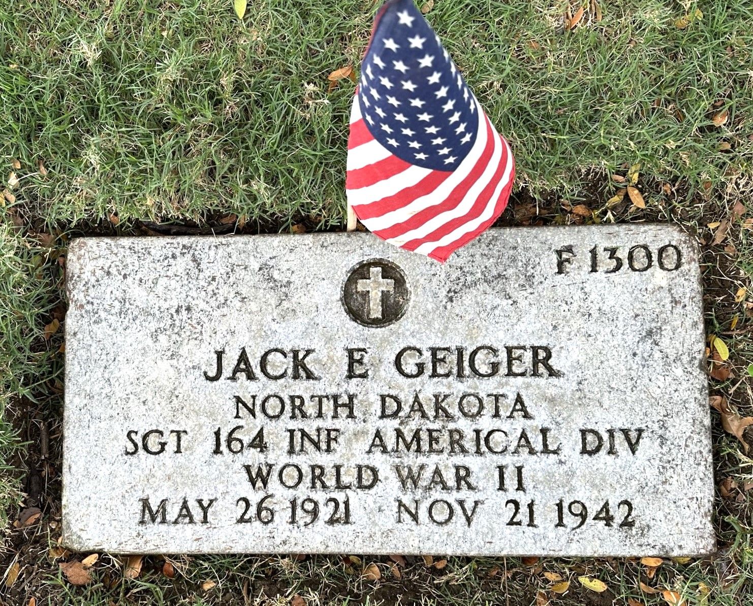Sergeant Jack E Geiger grave marker with small American flag photo