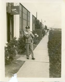 Major John Svenningsen in uniform standing on a sidewalk in front of a building photo