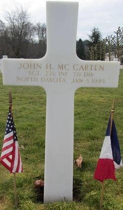 Sergeant John H McCarten cross grave marker with small flags photo