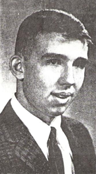 Douglas Kelly black and white photo, he is dressed formally in a suit and tie.