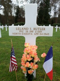 Private First Class Leland I Butler grave marker with flags and flowers photo