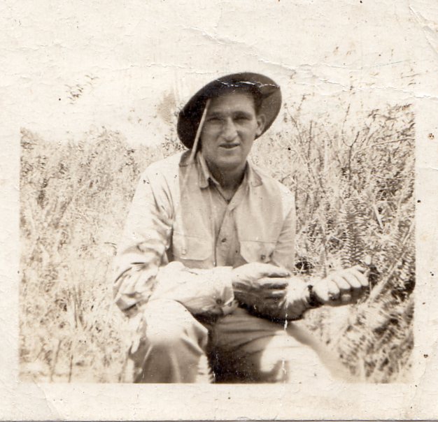 Private First Class Leo J Grossman in civilian clothes squatting down photo