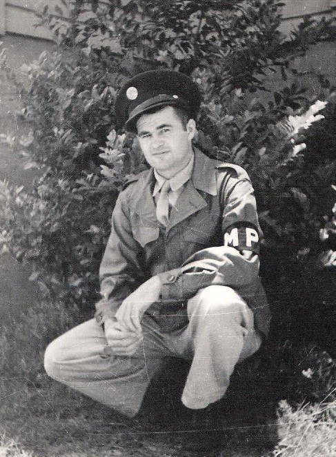 Private First Class Leonard Wohl in uniform in front of trees photo