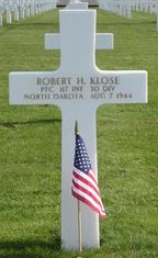 Private First Class Robert H Klose cross grave marker with small American Flag photo