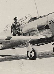 First Lieutenant Robert P Rist in uniform standing on wing of airplane photo