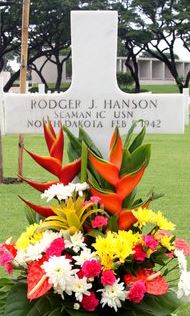 Seaman First Class Rodger J Hanson cross grave marker with bright flowers photo