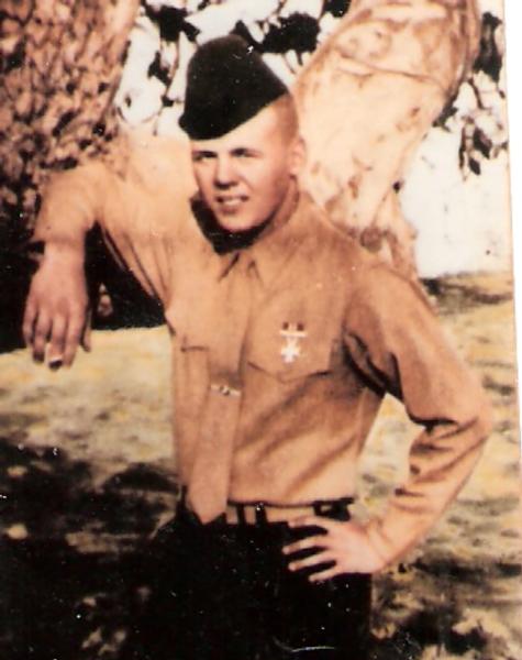 Photo of De Wayne Selby in uniform standing outside