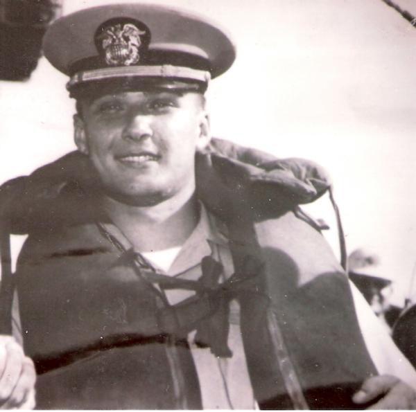 Thomas Spitzer in naval uniform wearing a life preserver. 