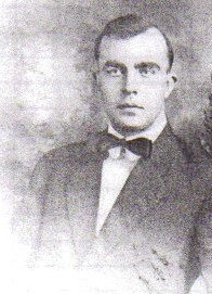 A vintage black-and-white portrait of Albert Vaughn wearing a dark suit and a bow tie.
