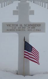 First Lieutenant Victor H Schneider cross grave marker with small American flag photo