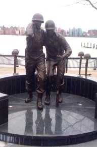WWII Memorial statue with two soldiers' photo