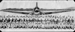Photo of military unit posed in front of an aircraft