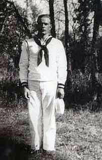 Seaman Second Class Wilferd Dewey Palmer in sailor uniform standing in front of trees photo