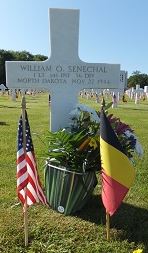 First Lieutenant William O Senechal cross grave marker with small flags and flowers photo