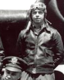 Staff Sergeant Alfred C Monson in uniform standing in front of an airplane photo
