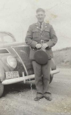 Private First Class Christ R Mertz in uniform standing in front of a car photo