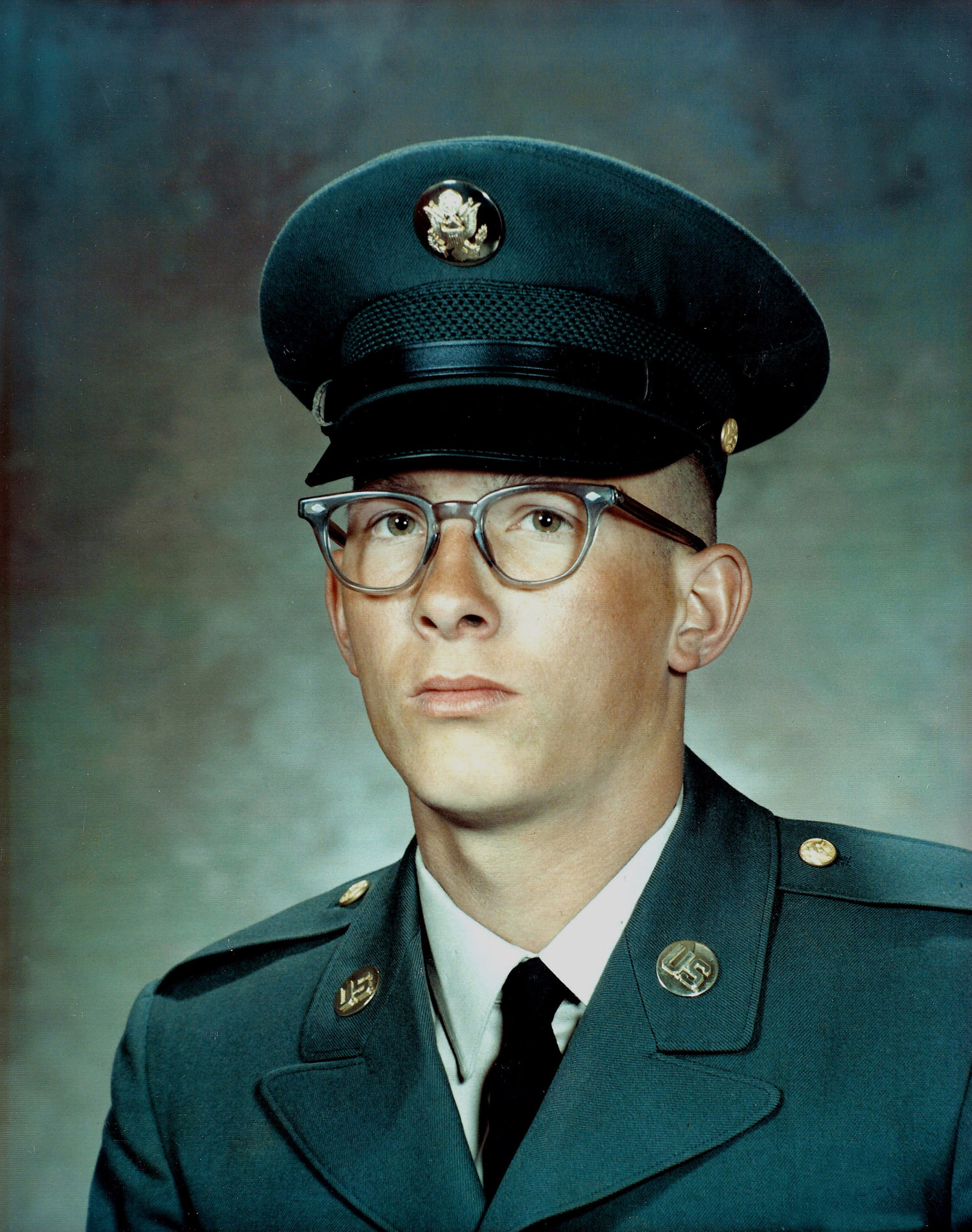 This is a formal studio portrait of a U.S. Army service member wearing the Army Green Class A uniform