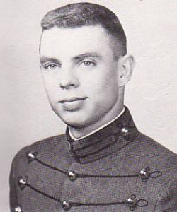 This is a black‑and‑white formal portrait of a young man wearing a high‑collared, button‑front military‑style uniform, photographed against a plain studio background.