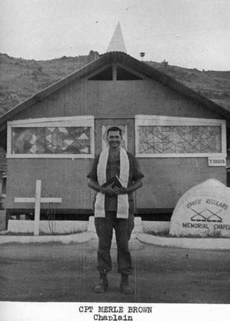 This photograph shows Captain Merle Brown, a U.S. Army chaplain, standing in front of a memorial chapel dedicated to the Sykes Regulars.