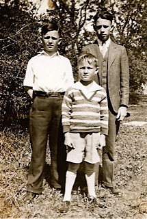 Private First Class Robert C Roche standing outside with two other young men photo