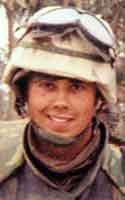 Keith Smette wearing a combat helmet with goggles resting on top and a dark neck gaiter